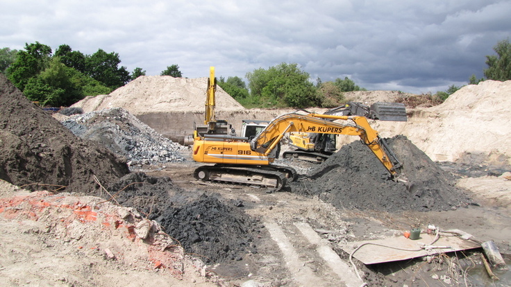 Bagger sortiert Bauschutt auf Baustelle