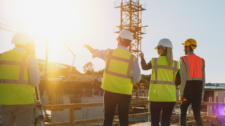 Vier Ingenieure betrachten eine Baustelle